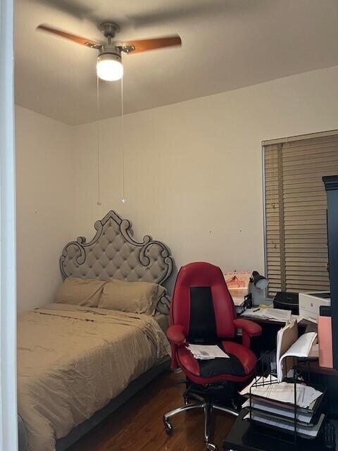 bedroom with dark hardwood / wood-style flooring and ceiling fan