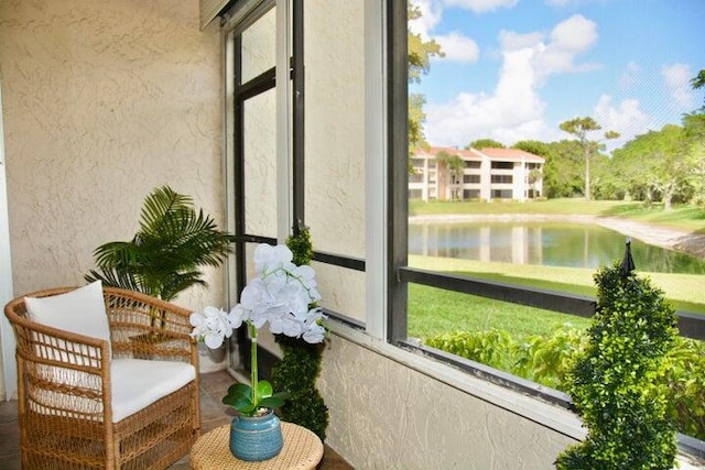 sunroom featuring a water view and a wealth of natural light