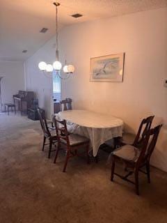 carpeted dining area featuring vaulted ceiling