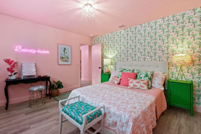 bedroom with wood-type flooring, radiator, a notable chandelier, and a textured ceiling