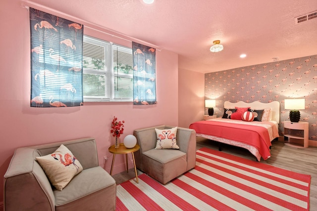 bedroom with wood-type flooring and a textured ceiling