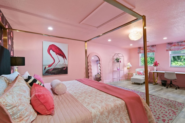 bedroom with a textured ceiling and light hardwood / wood-style floors