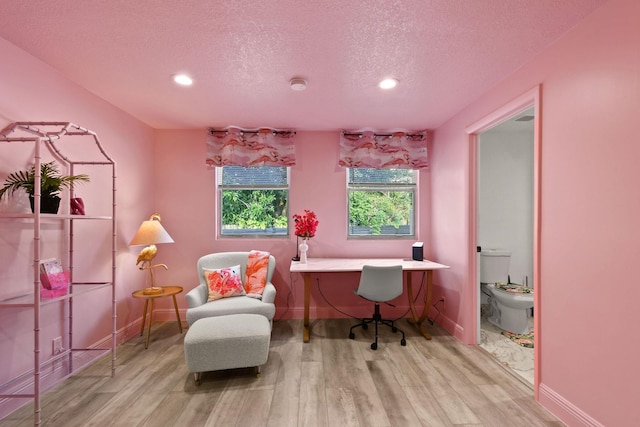 office with a textured ceiling and light hardwood / wood-style flooring