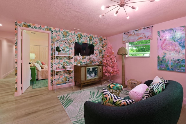 recreation room featuring hardwood / wood-style floors, a notable chandelier, and a textured ceiling