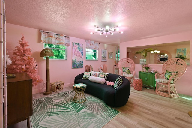 living room with a textured ceiling, light hardwood / wood-style flooring, and a chandelier