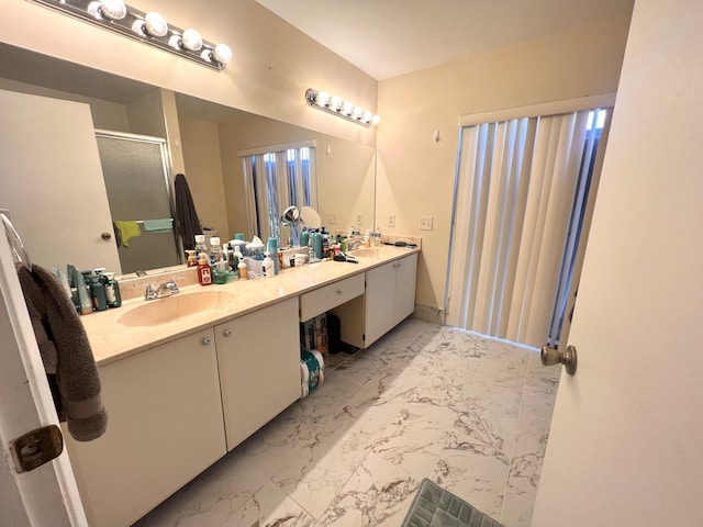 bathroom featuring a shower with door and vanity