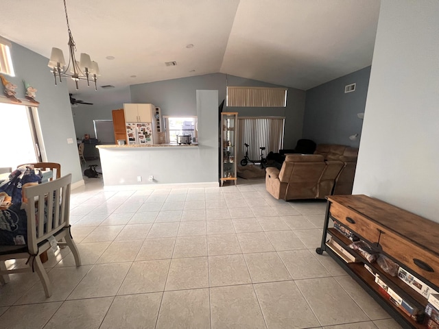 living room with light tile patterned flooring, lofted ceiling, and a notable chandelier