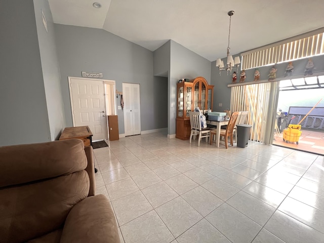 tiled dining room with a chandelier and high vaulted ceiling