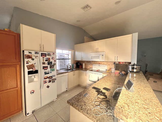 kitchen featuring white cabinetry, decorative backsplash, light stone counters, kitchen peninsula, and white appliances