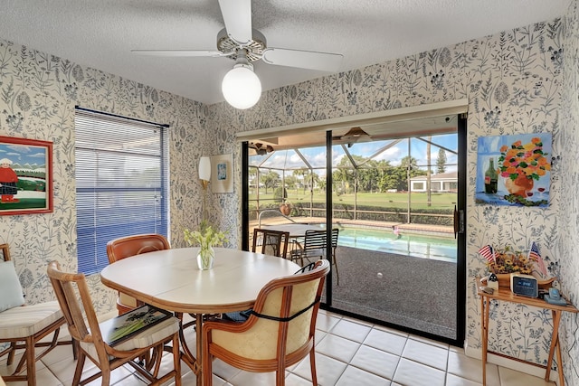 dining area featuring ceiling fan, light tile patterned floors, and a textured ceiling