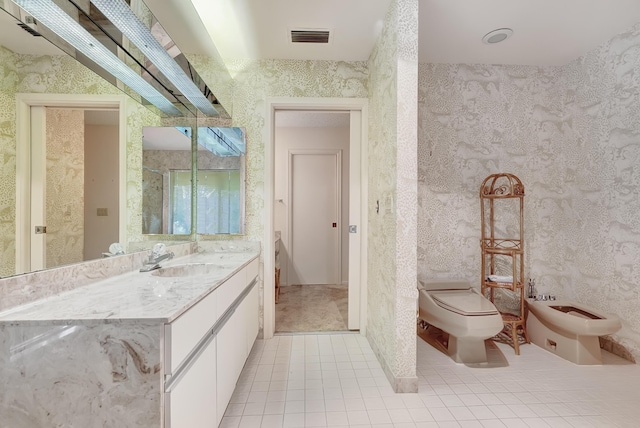 bathroom featuring a bidet, vanity, tile patterned floors, and toilet