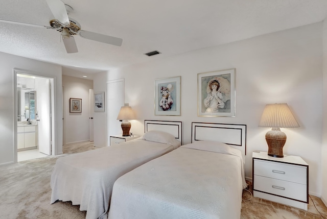 carpeted bedroom featuring ceiling fan and ensuite bath