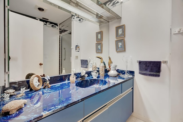 bathroom with vanity, tile patterned flooring, and a shower with door