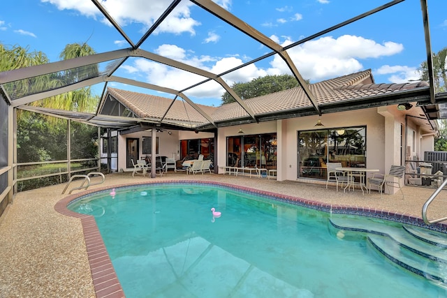 view of pool with a lanai, a patio, and ceiling fan