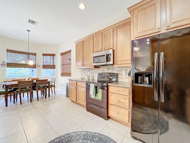 kitchen with light tile patterned flooring, appliances with stainless steel finishes, hanging light fixtures, and backsplash