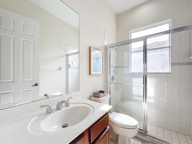 bathroom with vanity, an enclosed shower, and toilet