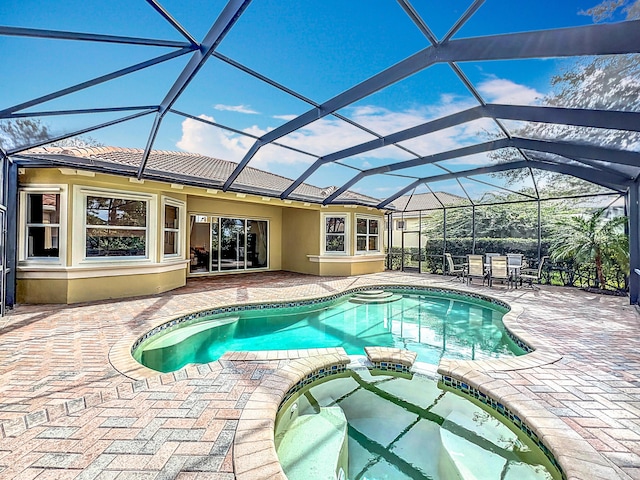 view of pool featuring an in ground hot tub, glass enclosure, and a patio