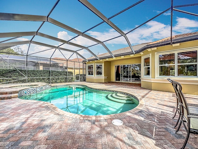 view of swimming pool with a lanai, a patio, and an in ground hot tub