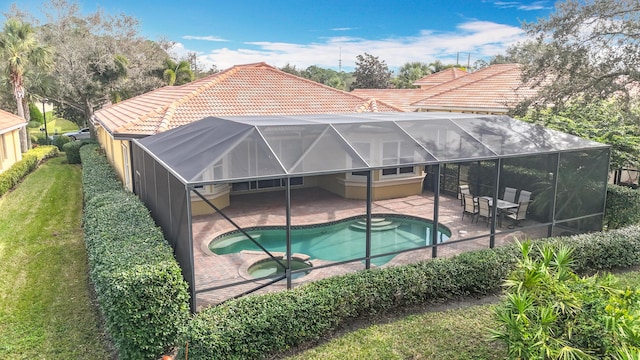 view of pool featuring an in ground hot tub, a lanai, a yard, and a patio area