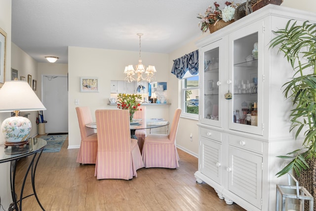 dining space with hardwood / wood-style flooring, an inviting chandelier, and a textured ceiling