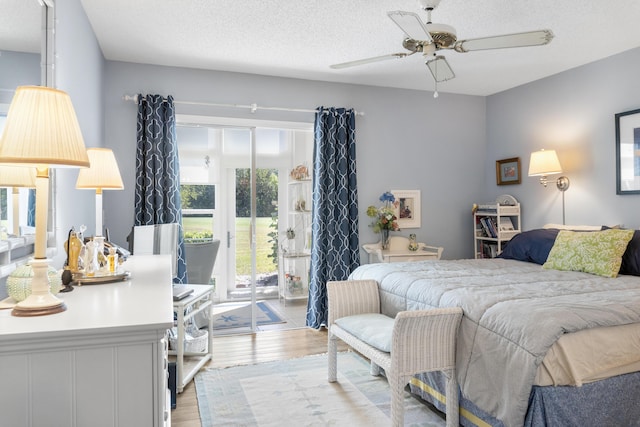 bedroom featuring a textured ceiling, access to exterior, and light wood-type flooring