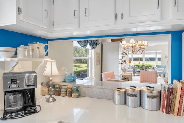 interior space with white cabinets and an inviting chandelier