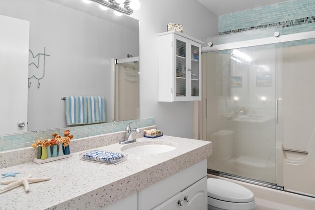 bathroom featuring vanity, backsplash, and toilet