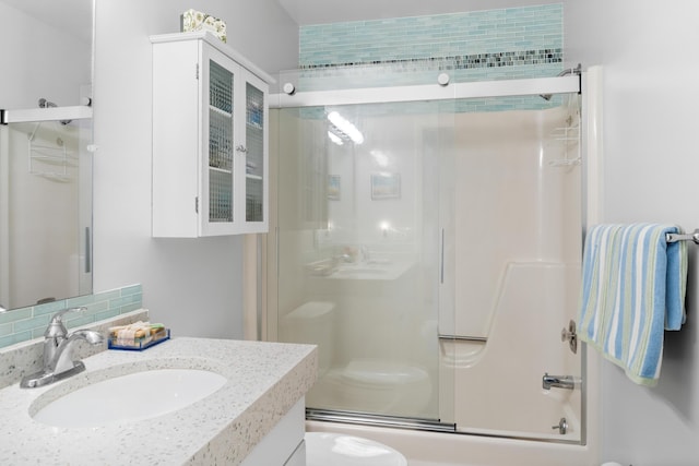 full bathroom with toilet, vanity, shower / bath combination with glass door, and backsplash