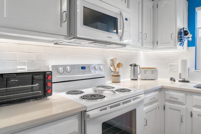 kitchen featuring white cabinets, white appliances, and decorative backsplash