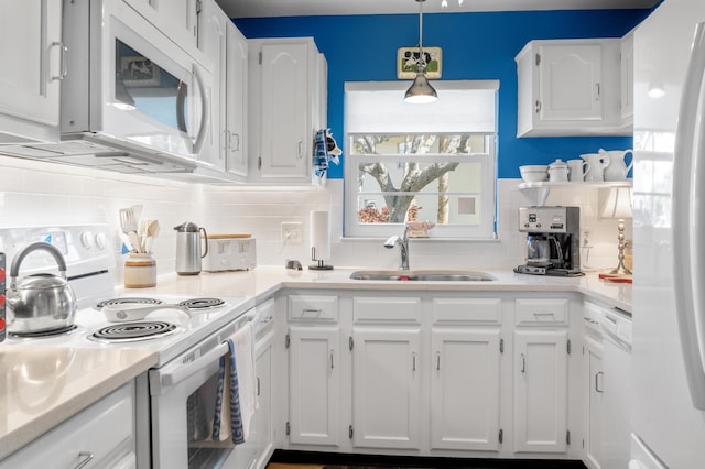 kitchen featuring sink, tasteful backsplash, hanging light fixtures, white appliances, and white cabinets