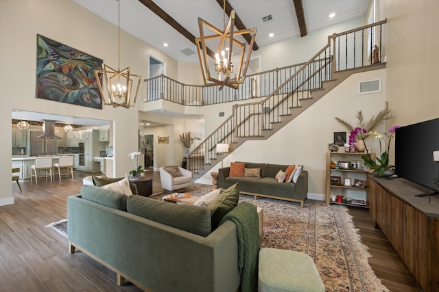 living room featuring a towering ceiling, wood-type flooring, beam ceiling, and a chandelier