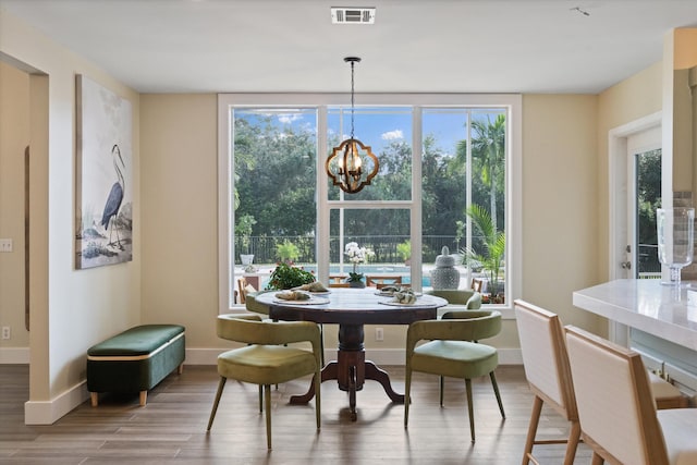 dining space with light hardwood / wood-style flooring and a chandelier