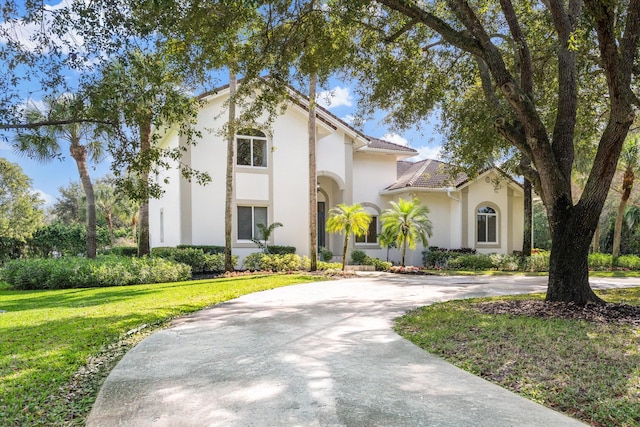 mediterranean / spanish-style home with a front yard