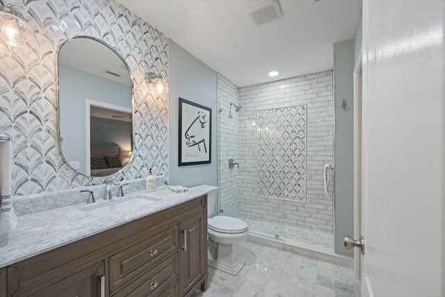 bathroom with vanity, toilet, and tiled shower