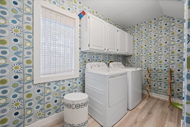 laundry room featuring cabinets, independent washer and dryer, and light hardwood / wood-style flooring