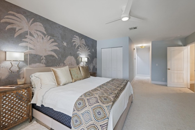 carpeted bedroom featuring ceiling fan and a closet