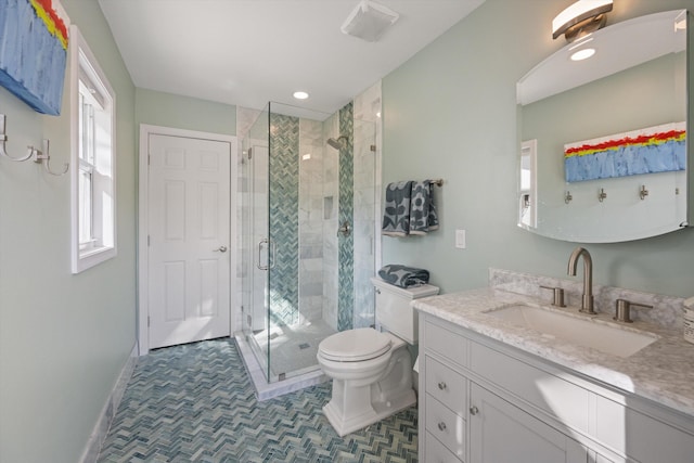 bathroom with vanity, a shower with door, and toilet