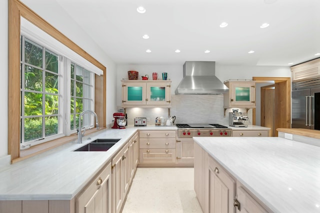 kitchen featuring sink, decorative backsplash, stainless steel appliances, light brown cabinets, and wall chimney exhaust hood