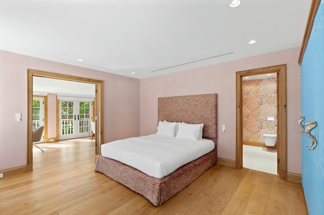 bedroom featuring ensuite bathroom, french doors, and light wood-type flooring