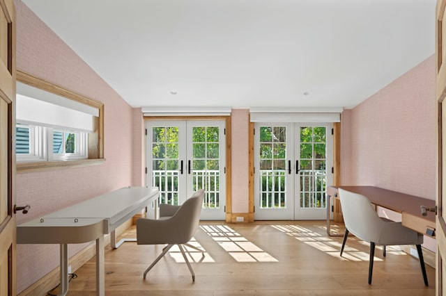 office featuring brick wall, light hardwood / wood-style flooring, and french doors