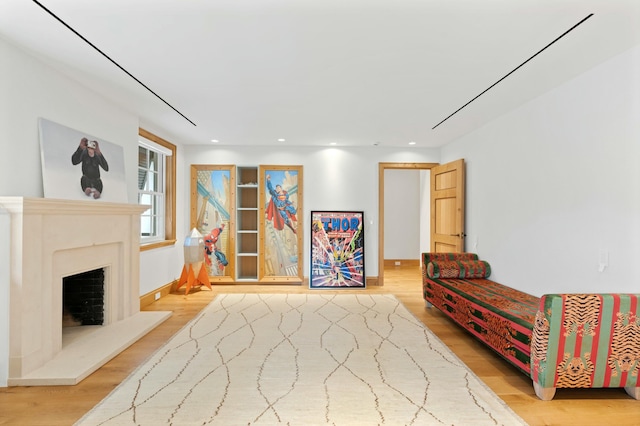 sitting room featuring a premium fireplace and light hardwood / wood-style floors