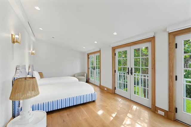 bedroom with multiple windows, access to exterior, french doors, and light wood-type flooring