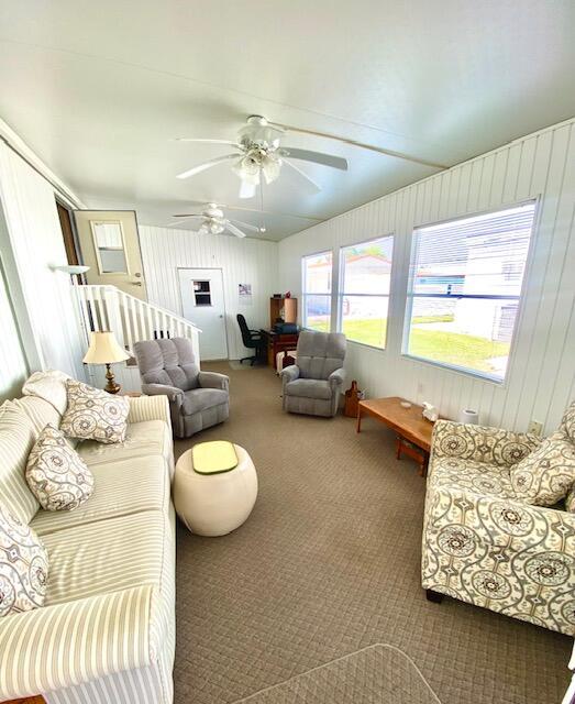 carpeted living room with ceiling fan