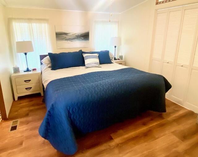 bedroom with vaulted ceiling, hardwood / wood-style floors, and a closet