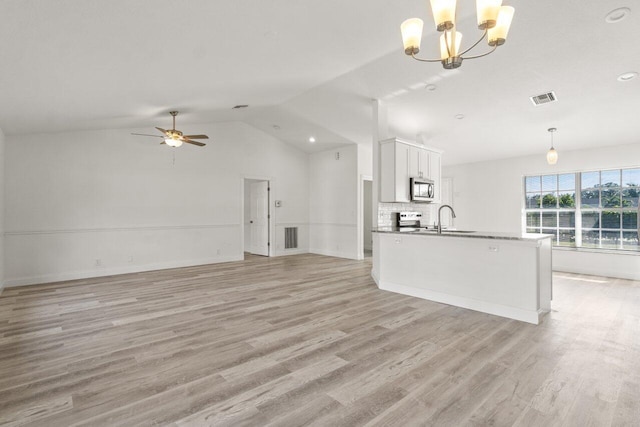 unfurnished living room featuring lofted ceiling, sink, ceiling fan with notable chandelier, and light wood-type flooring