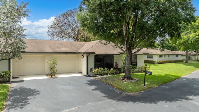 ranch-style house with a garage and a front lawn