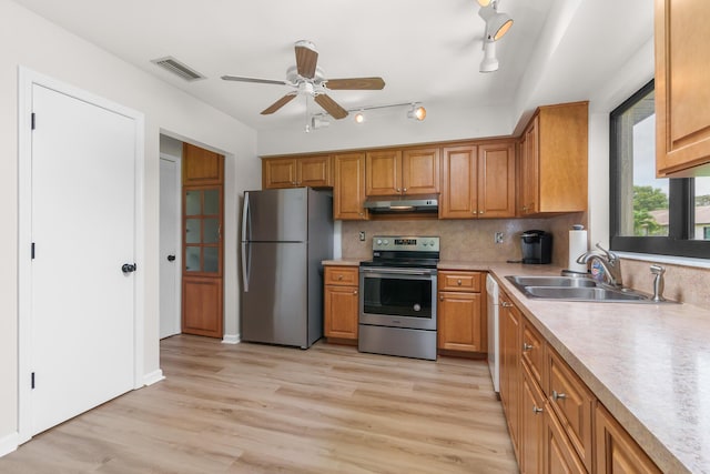 kitchen featuring stainless steel appliances, tasteful backsplash, sink, and light hardwood / wood-style floors