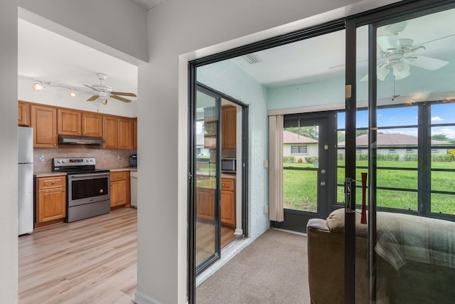 kitchen with tasteful backsplash, ceiling fan, stainless steel appliances, and light wood-type flooring