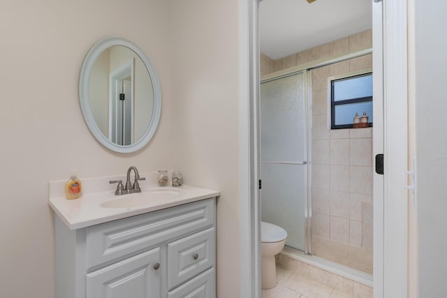 bathroom with walk in shower, vanity, tile patterned floors, and toilet