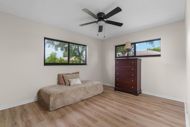 living area with plenty of natural light, light hardwood / wood-style floors, and ceiling fan